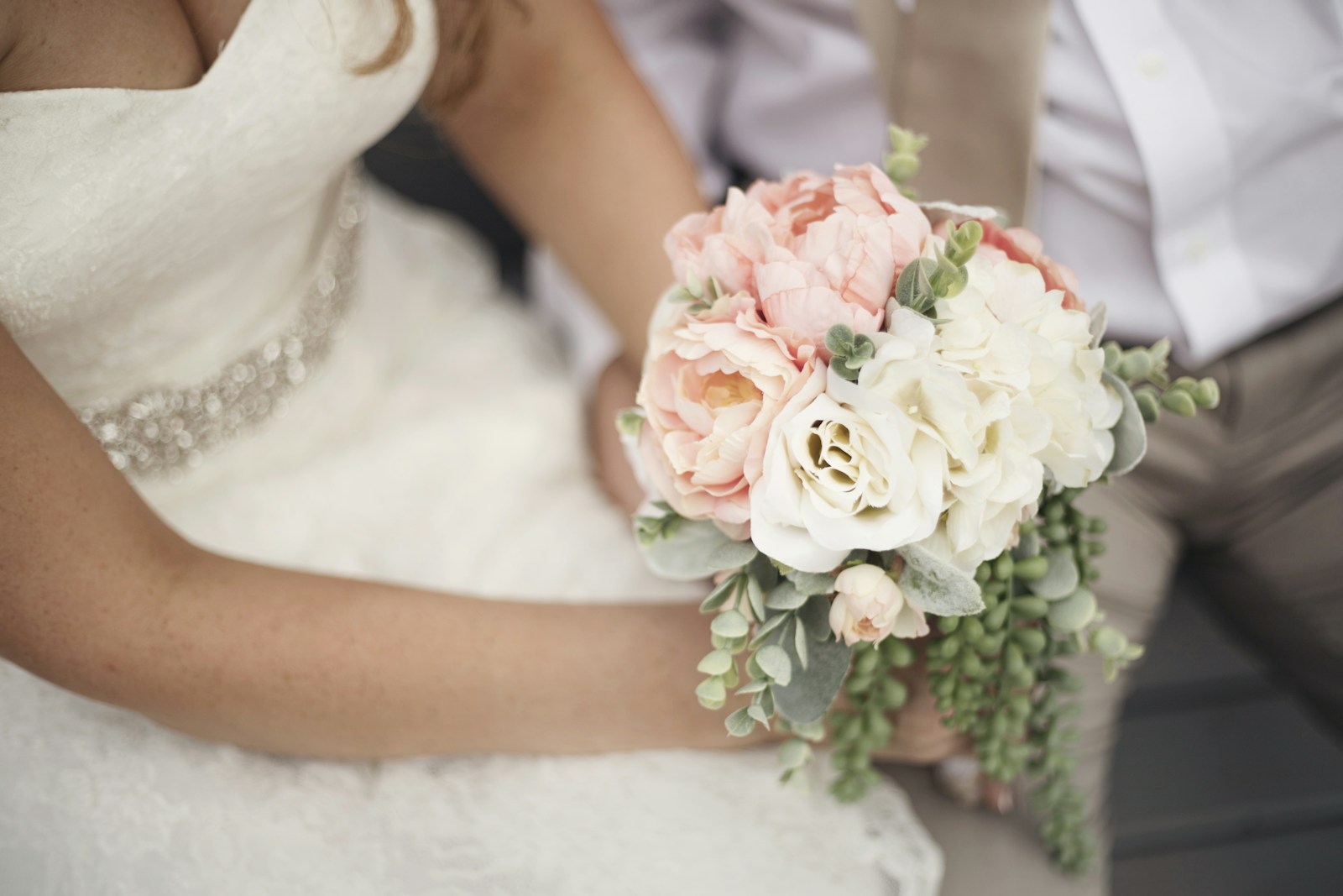 A bride holding a soft blush and ivory wedding bouquet